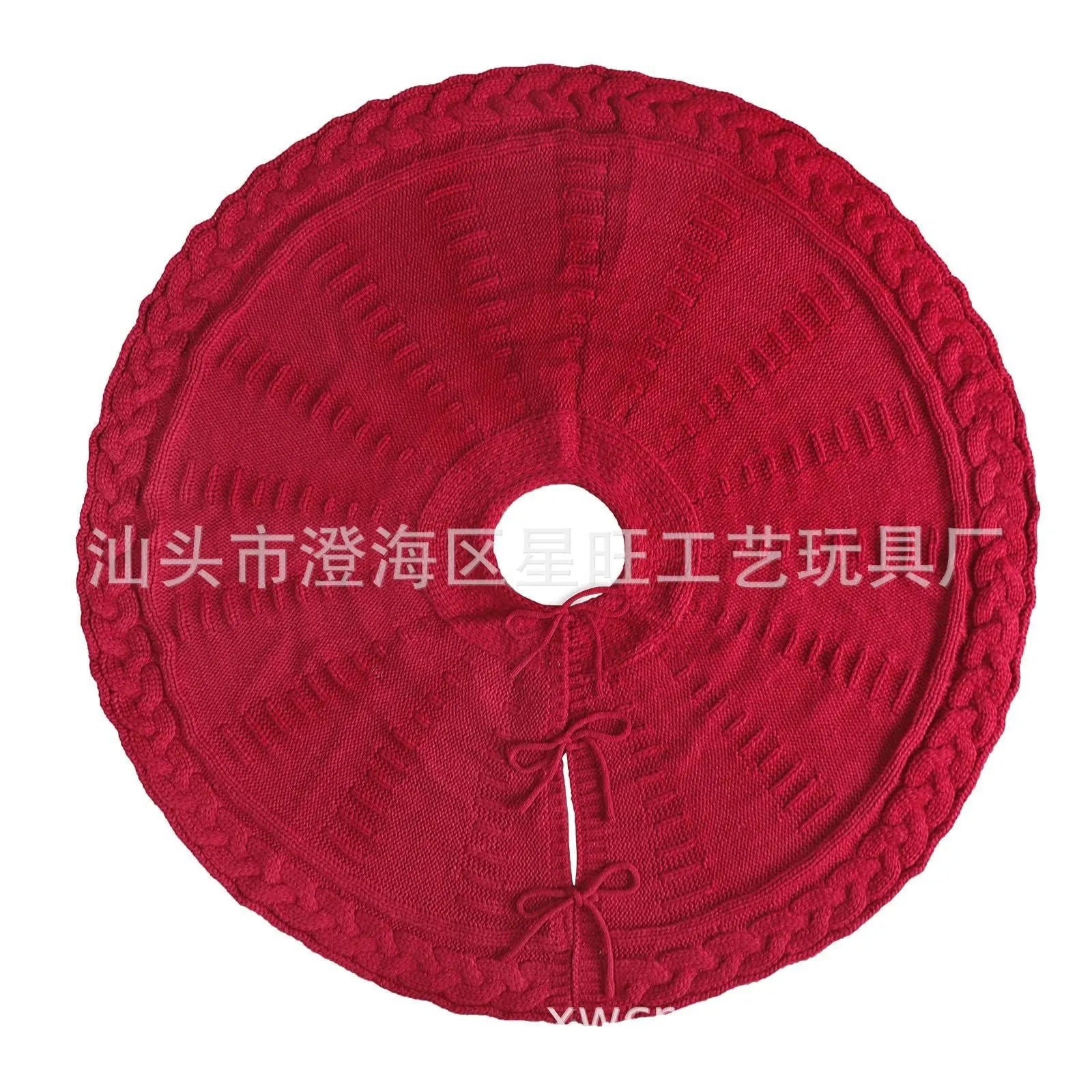 Red knitted wool Christmas tree skirt with 122cm diameter on floor under decorated tree