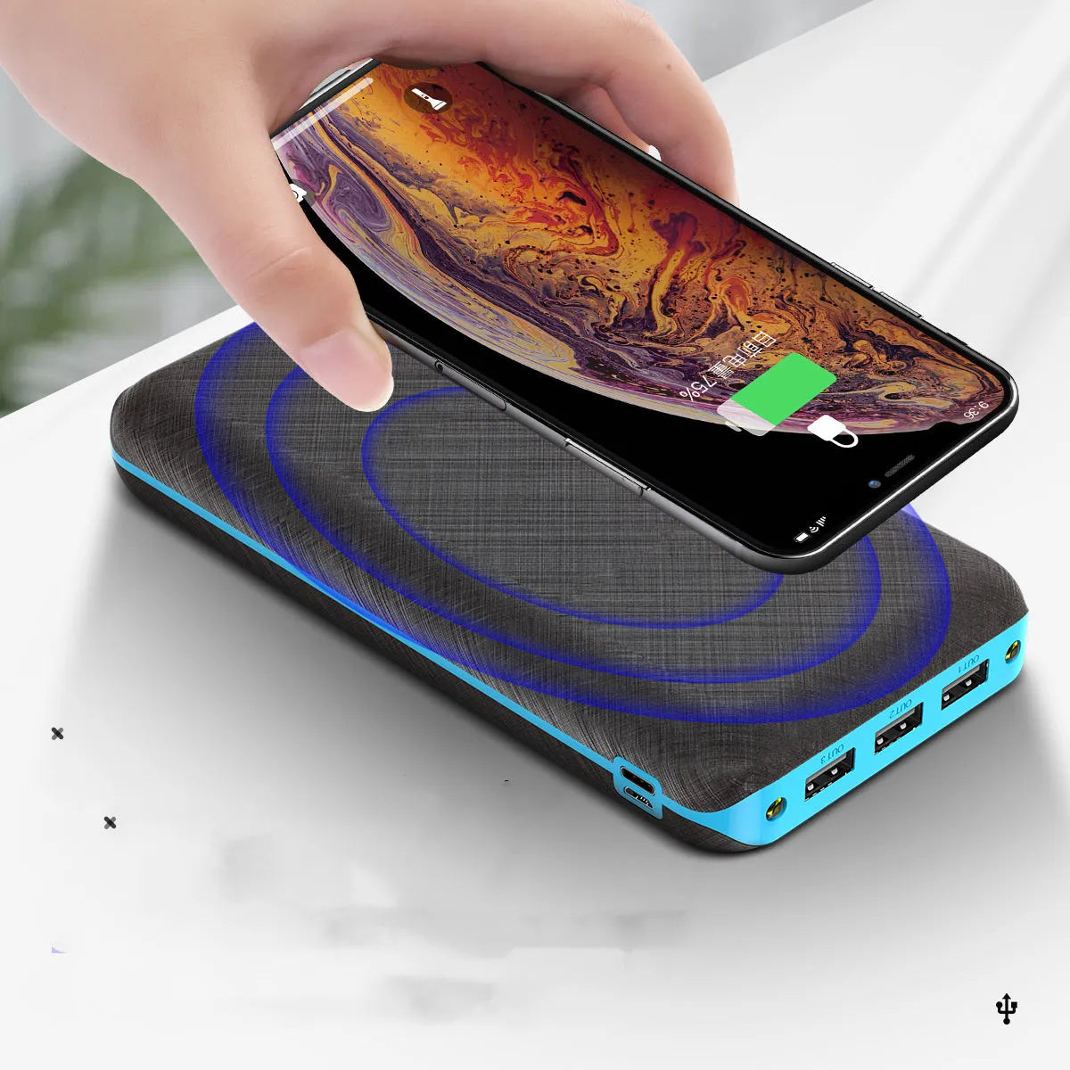 Black wireless power bank with Qi charging pad, three USB ports, and LED flashlight showing capacity display.