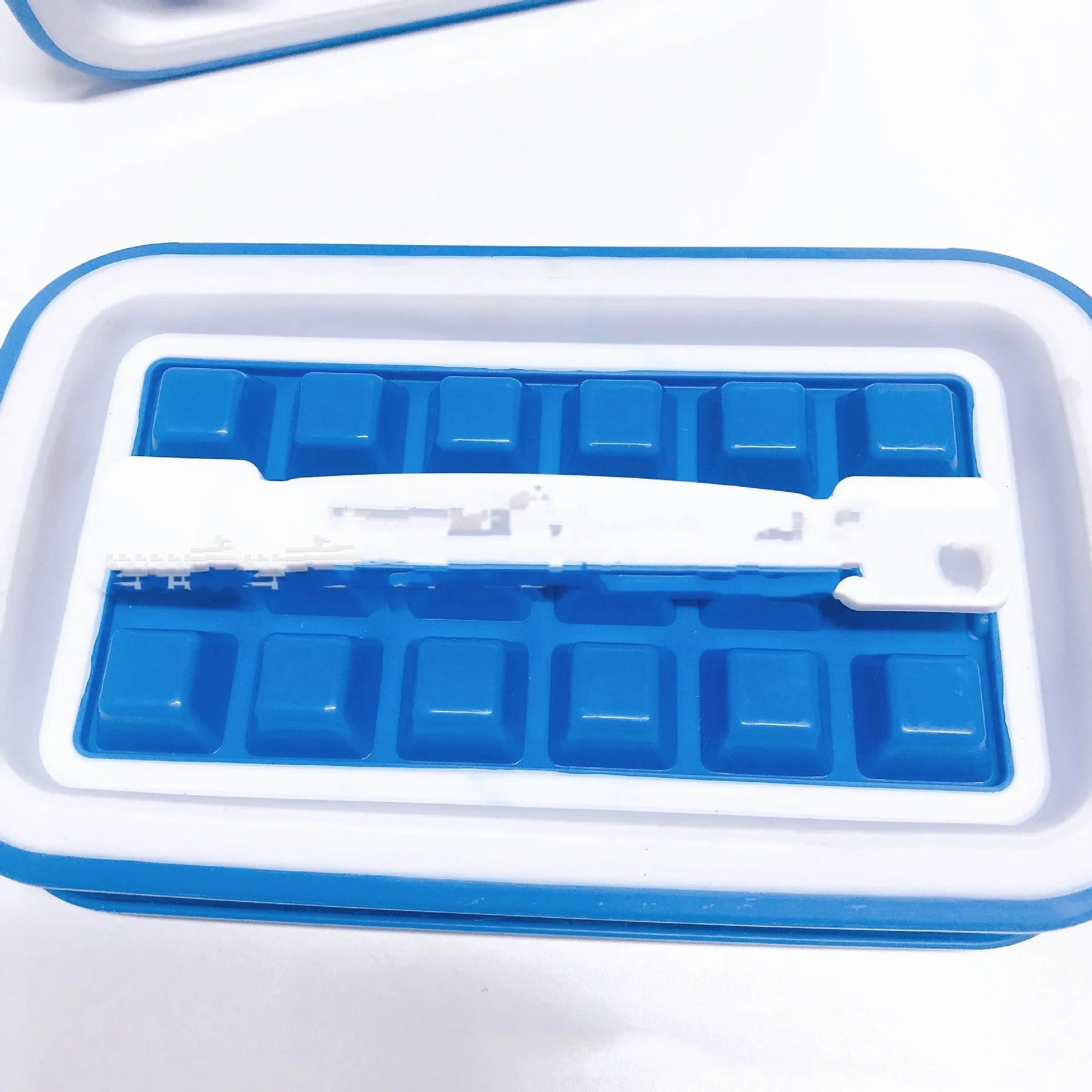 Blue silicone ice cube tray with 36 grid mould and lid on a white surface