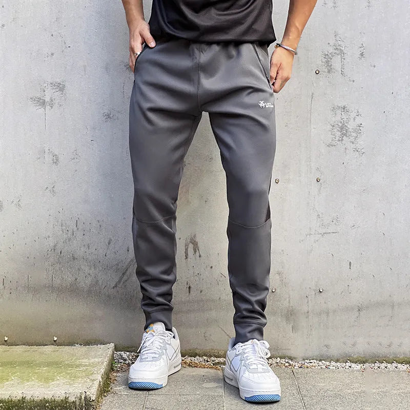 Men's deep gray stretch polyester sweatpants with panel zip pockets, side view