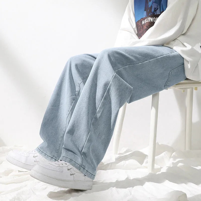 Men's straight loose jeans in black cotton knit fabric with mid waist, shown on a model.