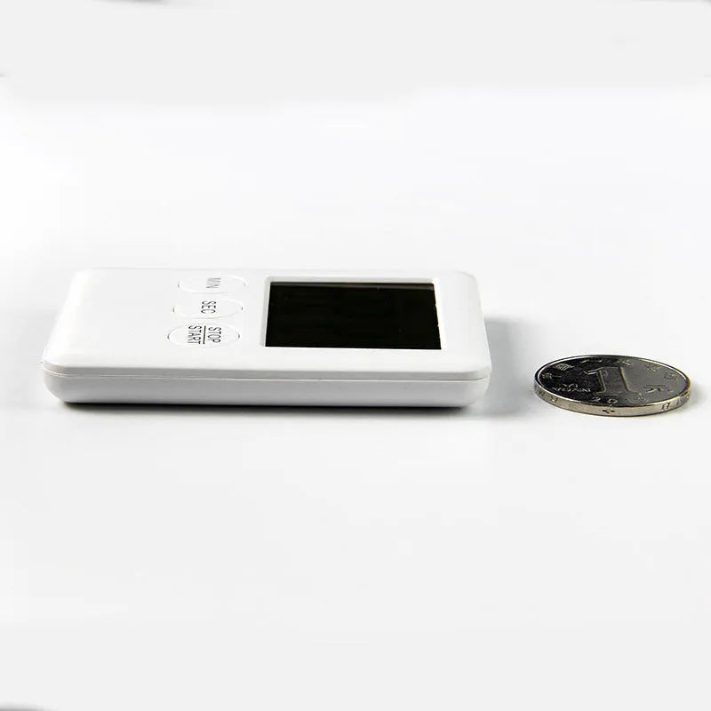 Black and white digital kitchen timer with magnetic back and display showing countdown time.