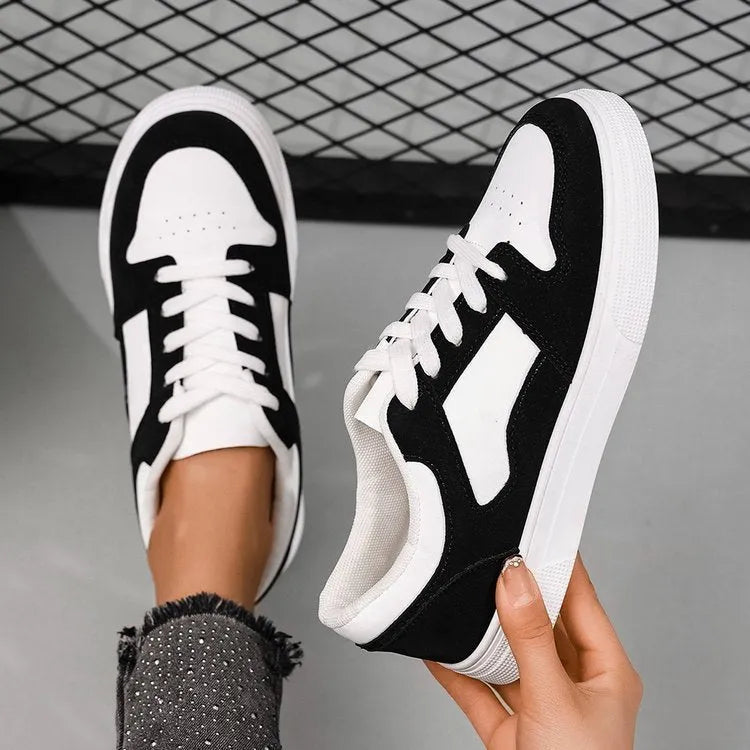 Black women's casual sports shoes with round toe and lace-up front, featuring a low top and flat rubber sole.