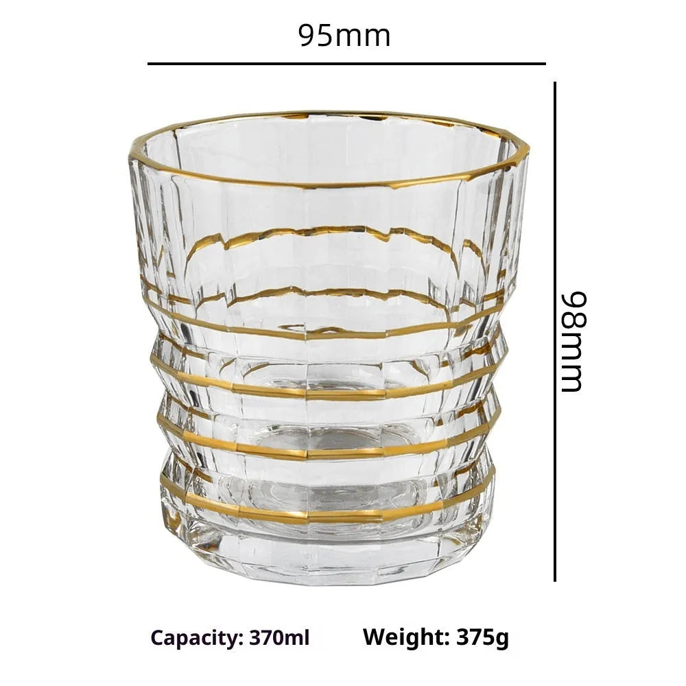 Crystal glass whiskey shot glass with solid gold finish on a bar counter