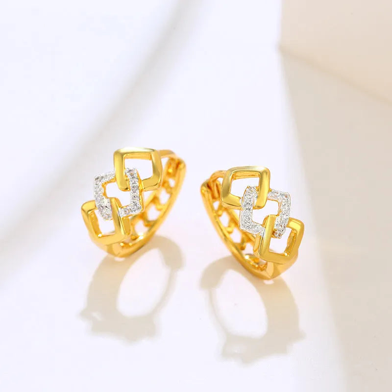 Gold electroplated geometric hollow-out earrings with ear clip fastening on white background