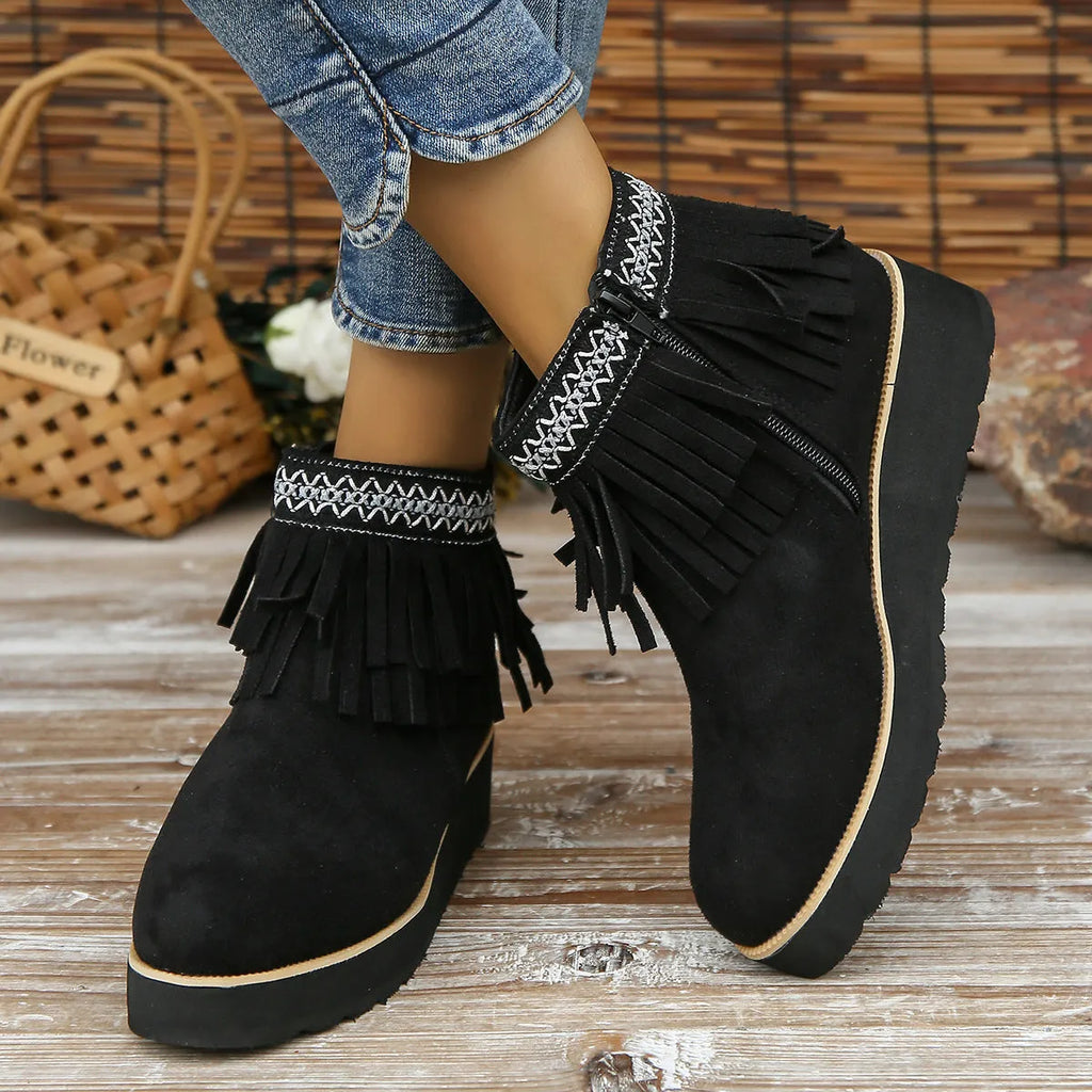 Women's dark brown suede wedge ankle boots with side zipper and tassel detail on a thick rubber sole.