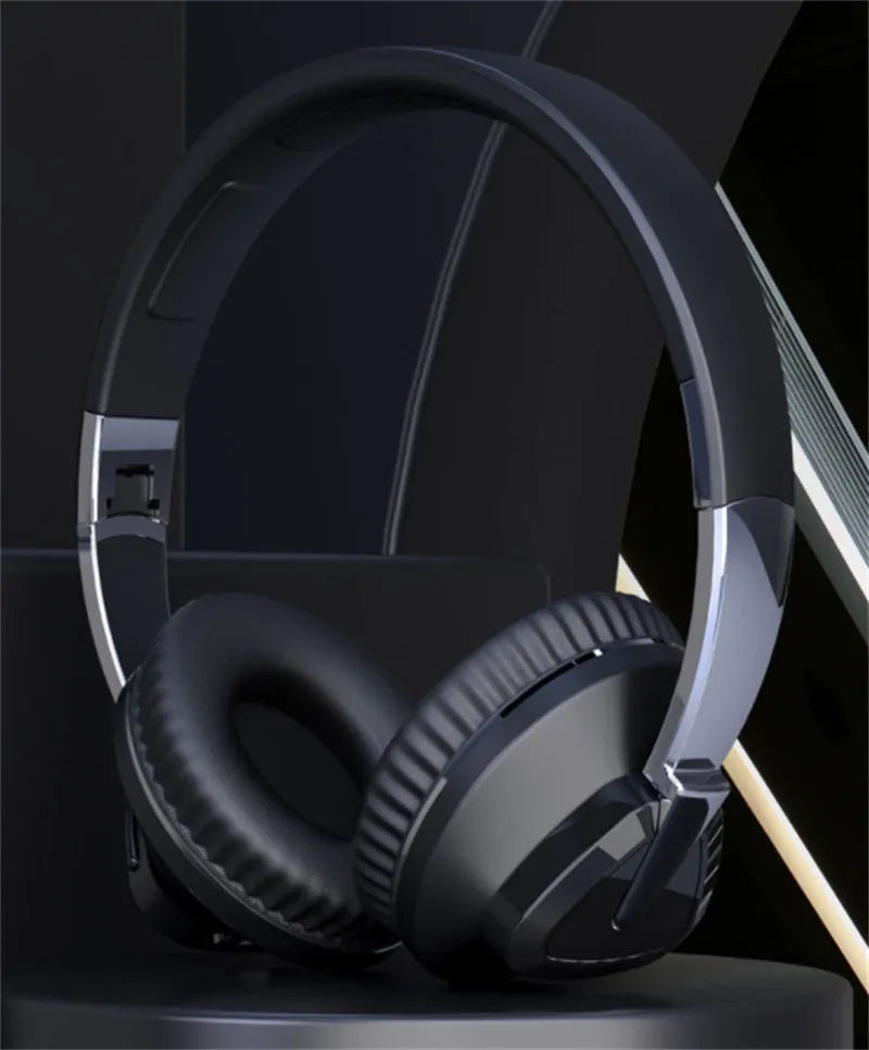 Wireless over-ear headset in black with soft ear cushions, showing AUX audio jack port.