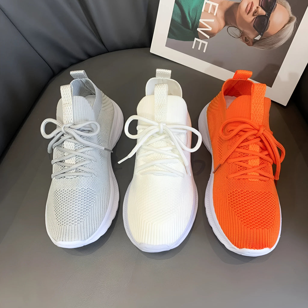 Women's low-top mesh running shoes in creamy white with Flyknit upper and rubber sole.