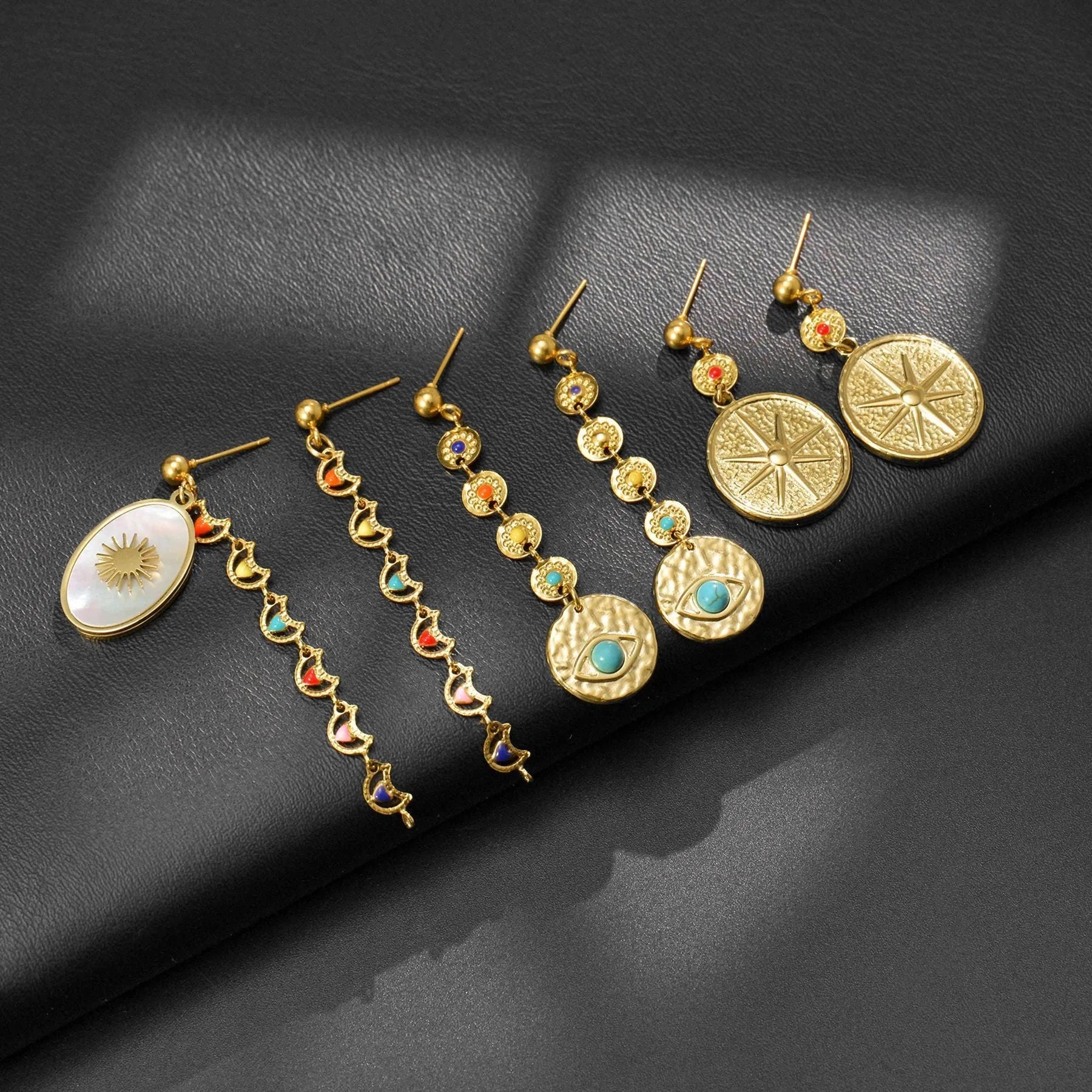 Stainless steel geometric drop earrings in Eight Awn Star, Eye, and Shell Sun designs.