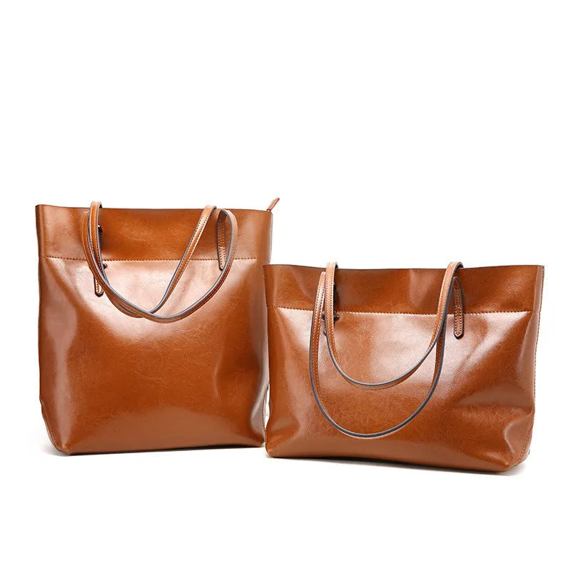 Horizontal leather crossbody handbag in waxed cowhide with two main compartments and a phone pouch.
