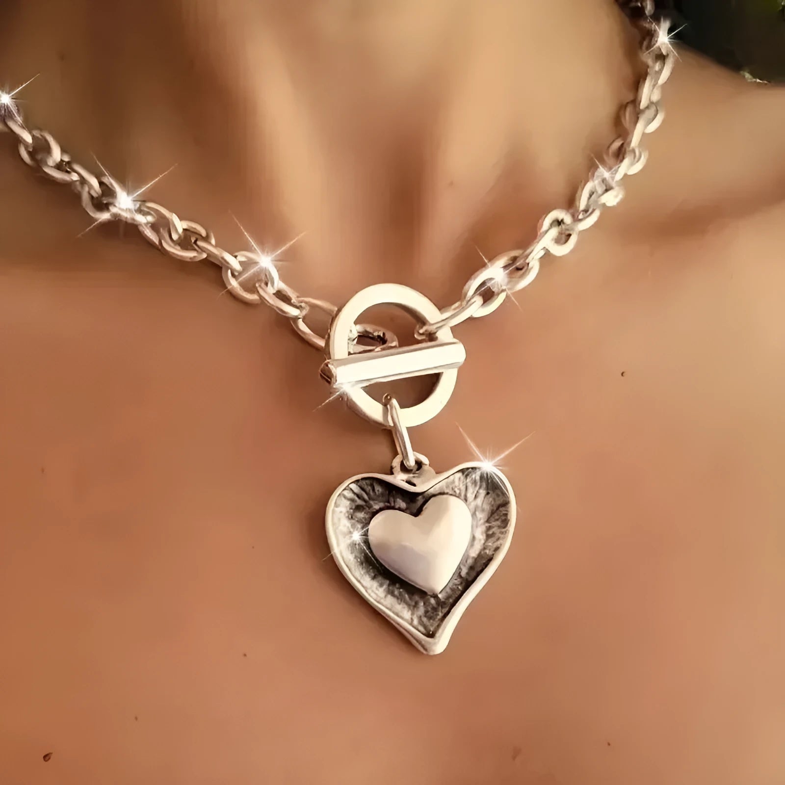 Titanium steel heart pendant necklace with water wave chain on model – stainless steel colour, clavicle length