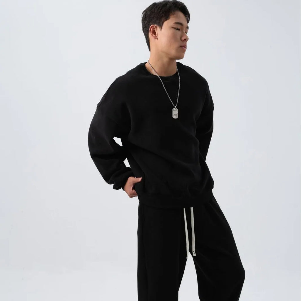 Men's black polar fleece sports suit with loose long sleeve coat and matching trousers on a hanger.