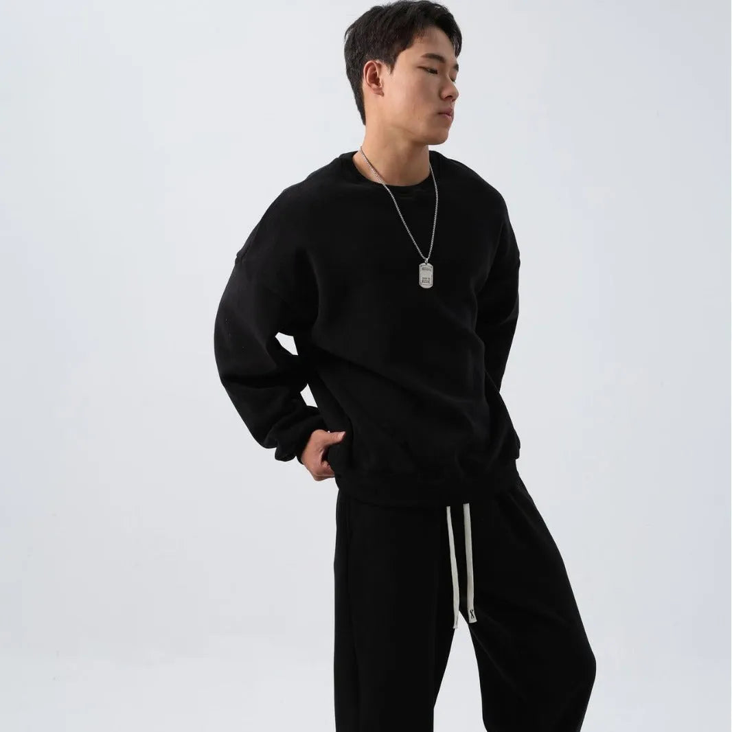 Men's black polar fleece sports suit with loose long sleeve coat and matching trousers on a hanger.