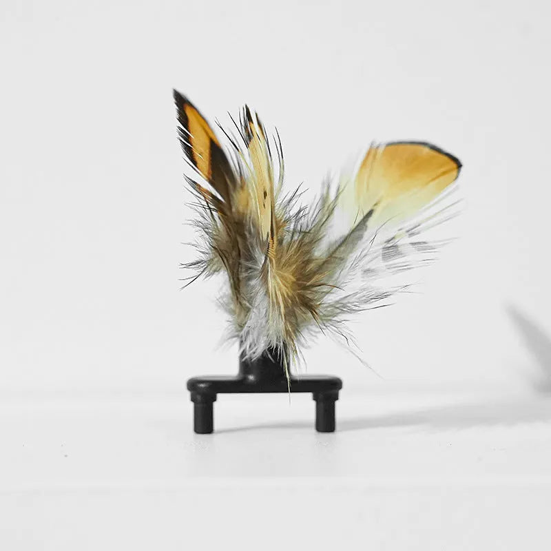 Pink and yellow bee-themed electric cat toy with feather attachment on floor