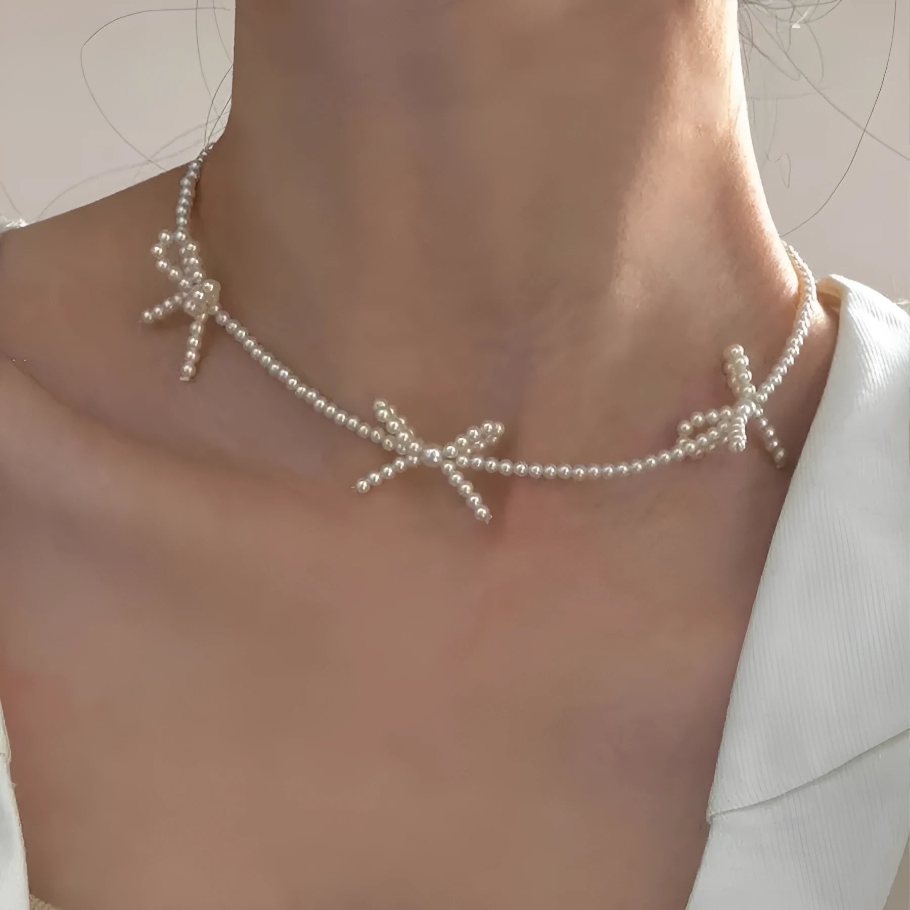 White adjustable pearl necklace with bow detail measuring 31-40cm