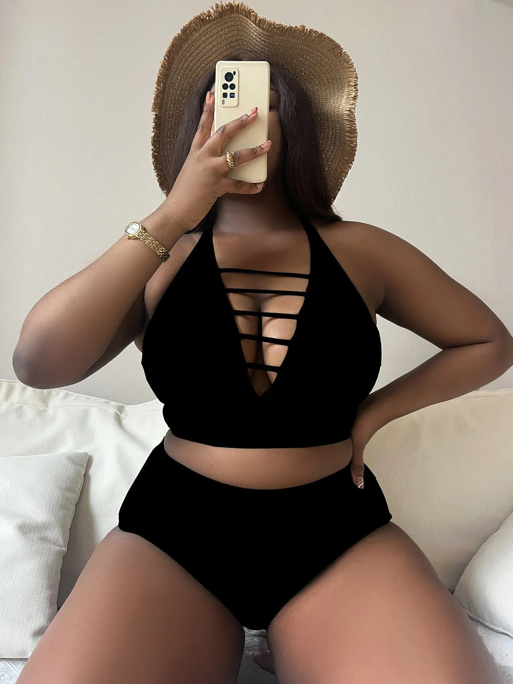 Plus size woman in a black halter bikini with cross shoulder straps and high-waisted briefs.
