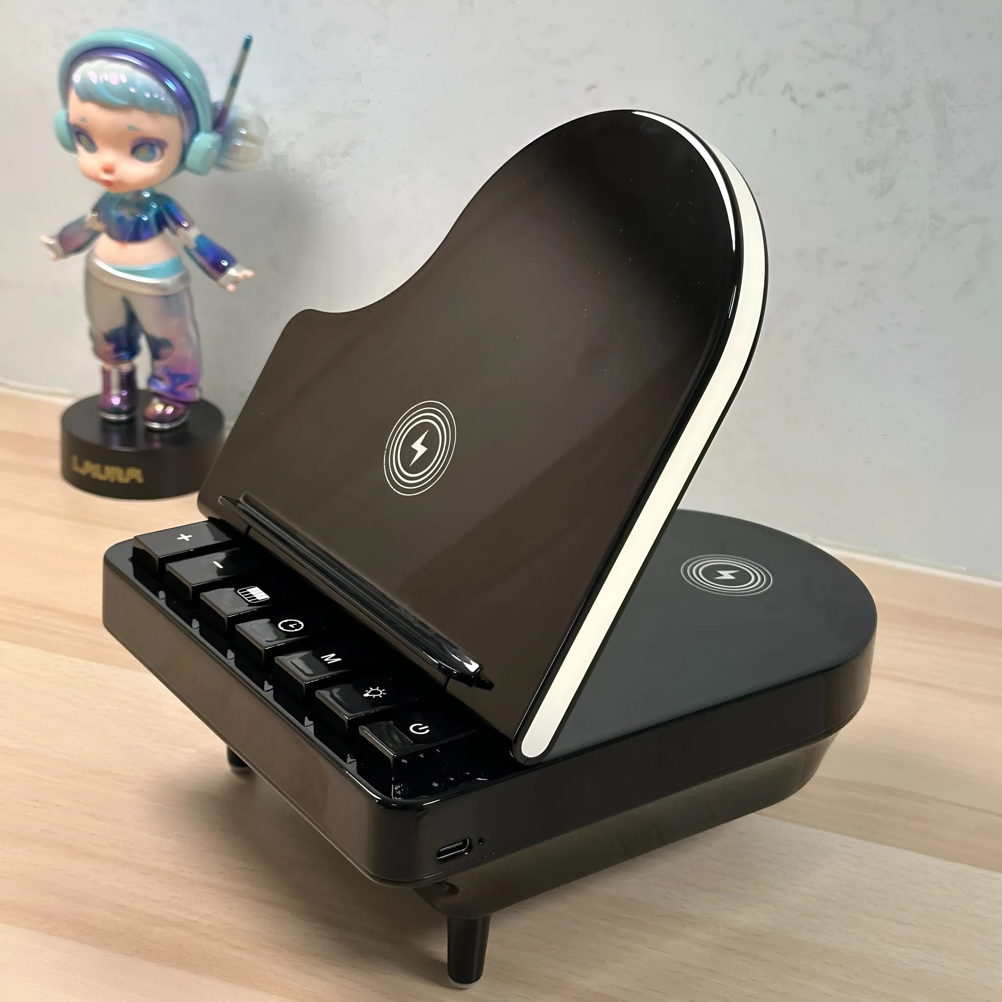 Black multi-function Bluetooth speaker with wireless charger and phone holder on a desk