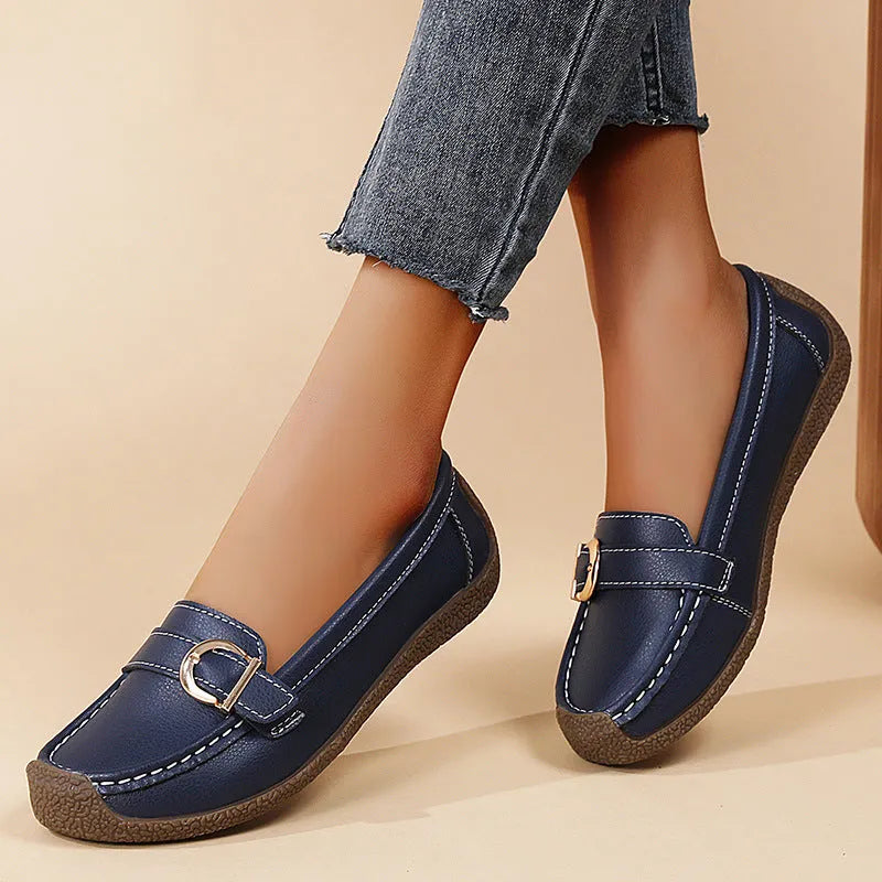 Women's beige casual loafers with round toe, flat heel, and slip-on design on a plain background.