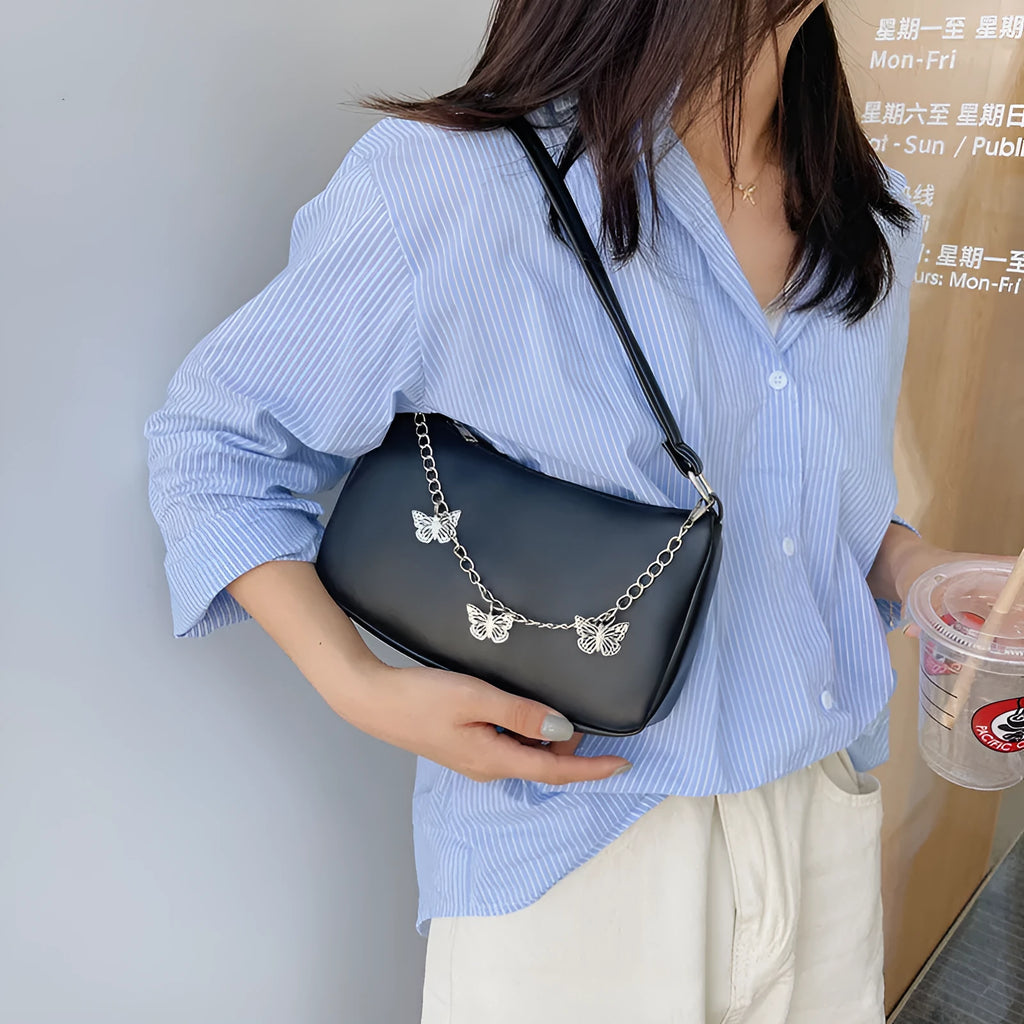 Black butterfly chain underarm bag with crossbody strap showing internal mobile phone and document compartments