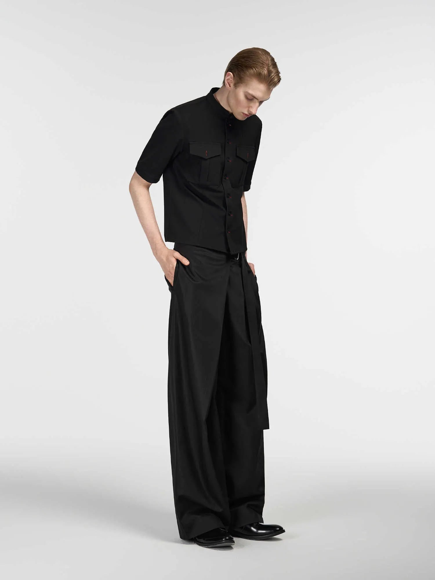 Black straight-leg trousers with a single pleat and adjustable waistband on a neutral background.