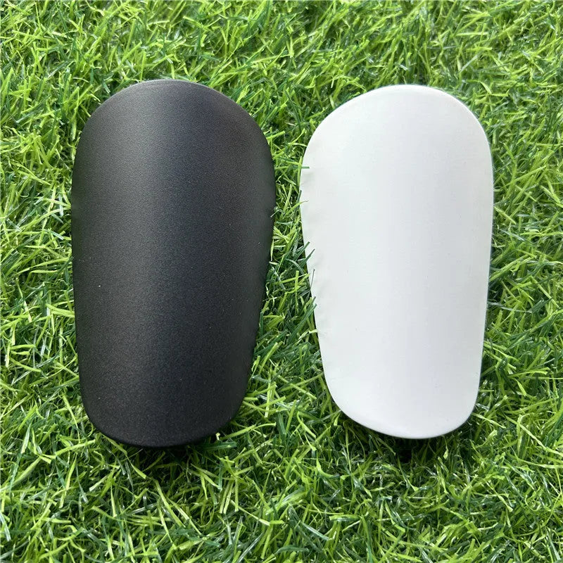 Extra small mini football shin guards measuring 8x5cm in black and white plastic construction