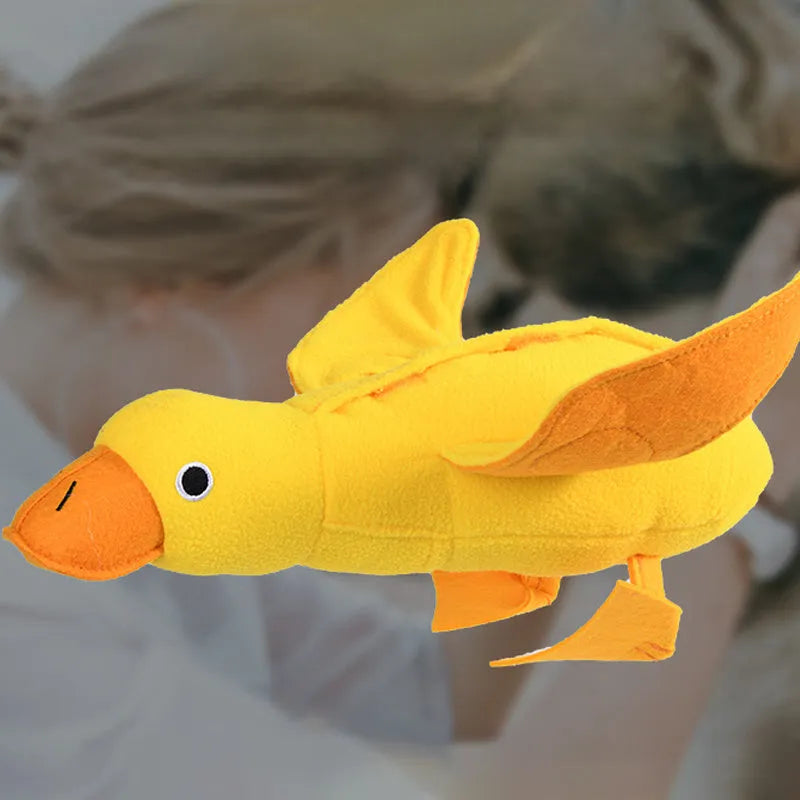 Yellow plush duck dog toy with squeaker and treat-dispensing feature for training and play.