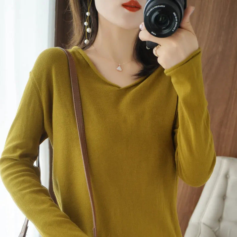 Women's V-neck long sleeve knit top in turmeric colour on a hanger