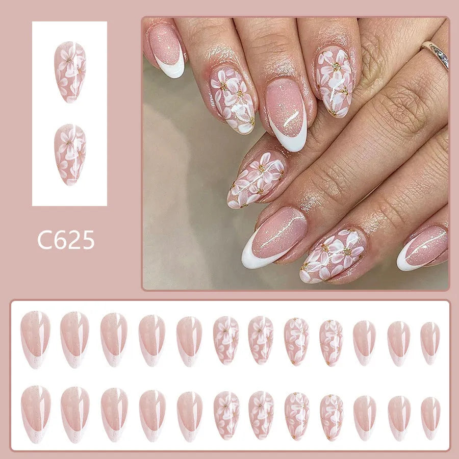 Short almond-shaped false nails with French tips and glitter powder flower decoration