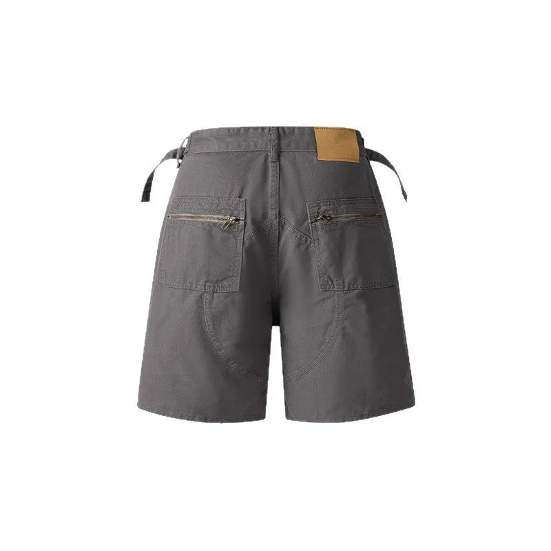 Retro loose-fit washed cotton workwear shorts for men and women on a hanger, showing zip fly and fifth-pants length.