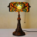 Tiffany table lamp with coloured glass lampshade and stained glass resin base on wooden desk