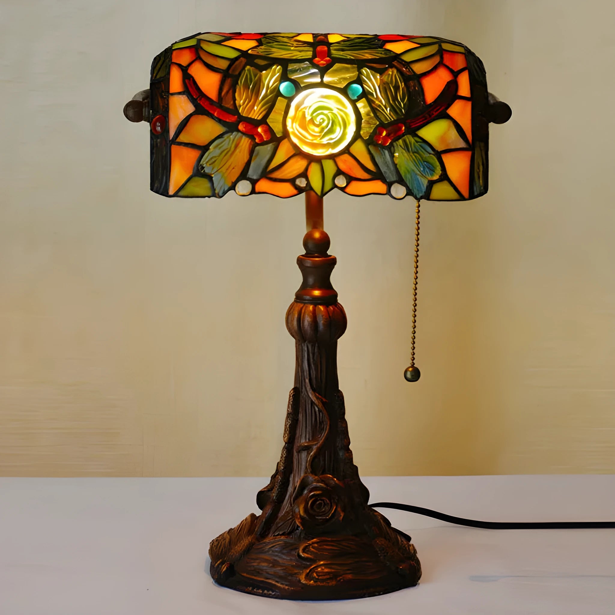 Tiffany table lamp with coloured glass lampshade and stained glass resin base on wooden desk