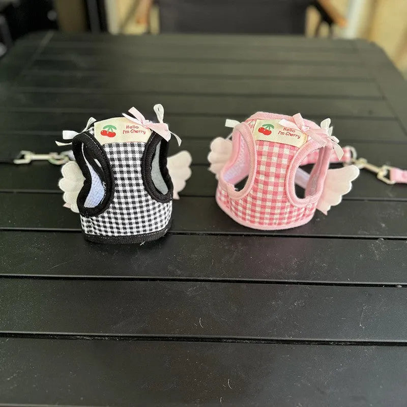 Small dog wearing pink cotton chest-back harness with hand holding rope attached