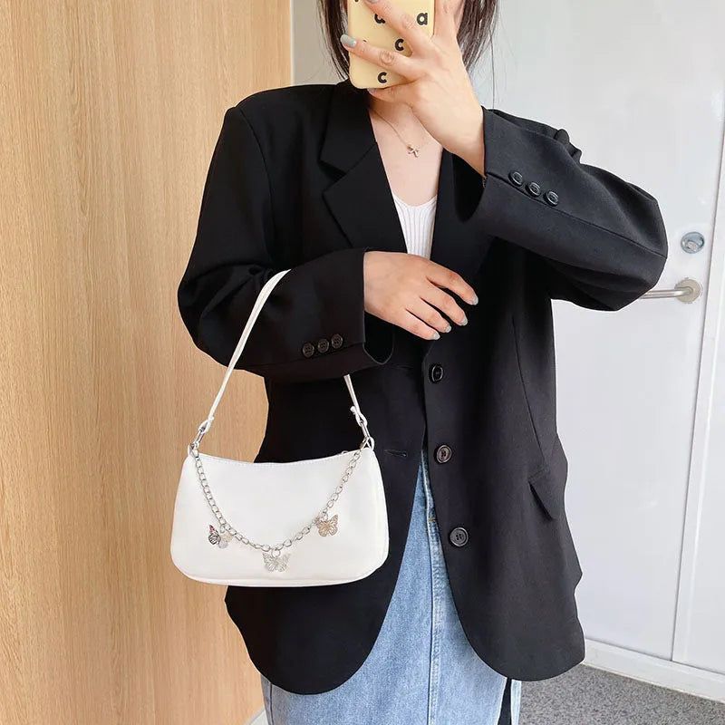 Black butterfly chain underarm bag with crossbody strap showing internal mobile phone and document compartments
