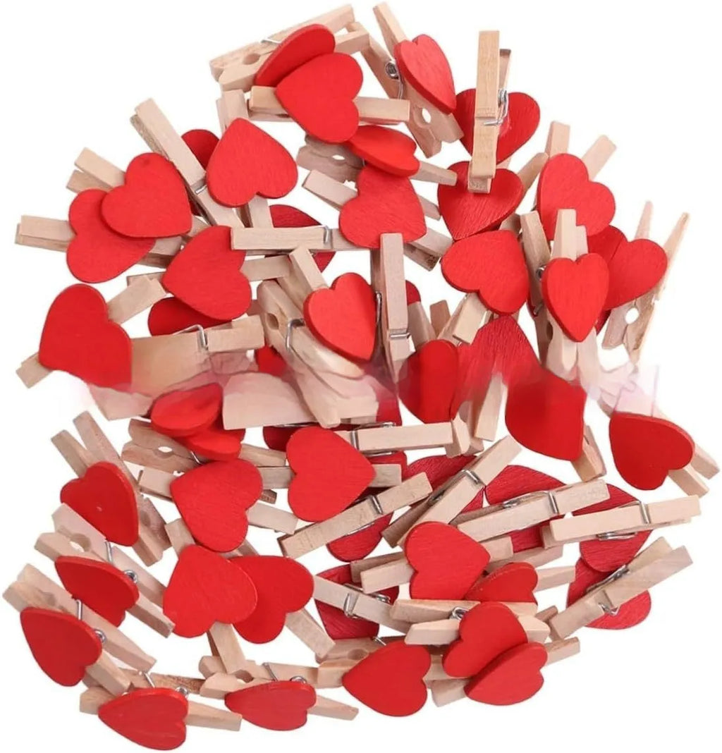 Set of five solid wood heart-shaped clips in red, white, and rose red on a plain surface.