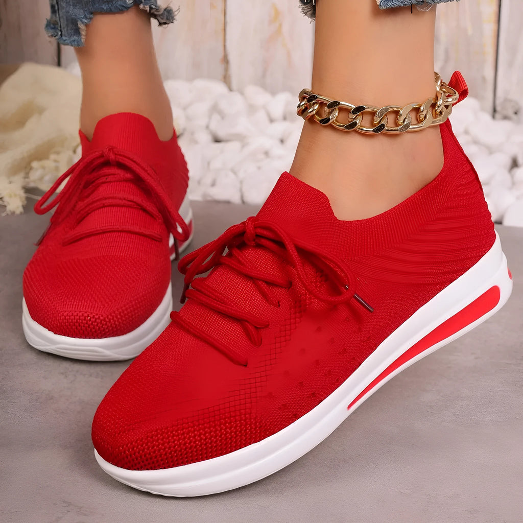 Women's black fly-knit style casual sneakers with lace-up front and low-top design.