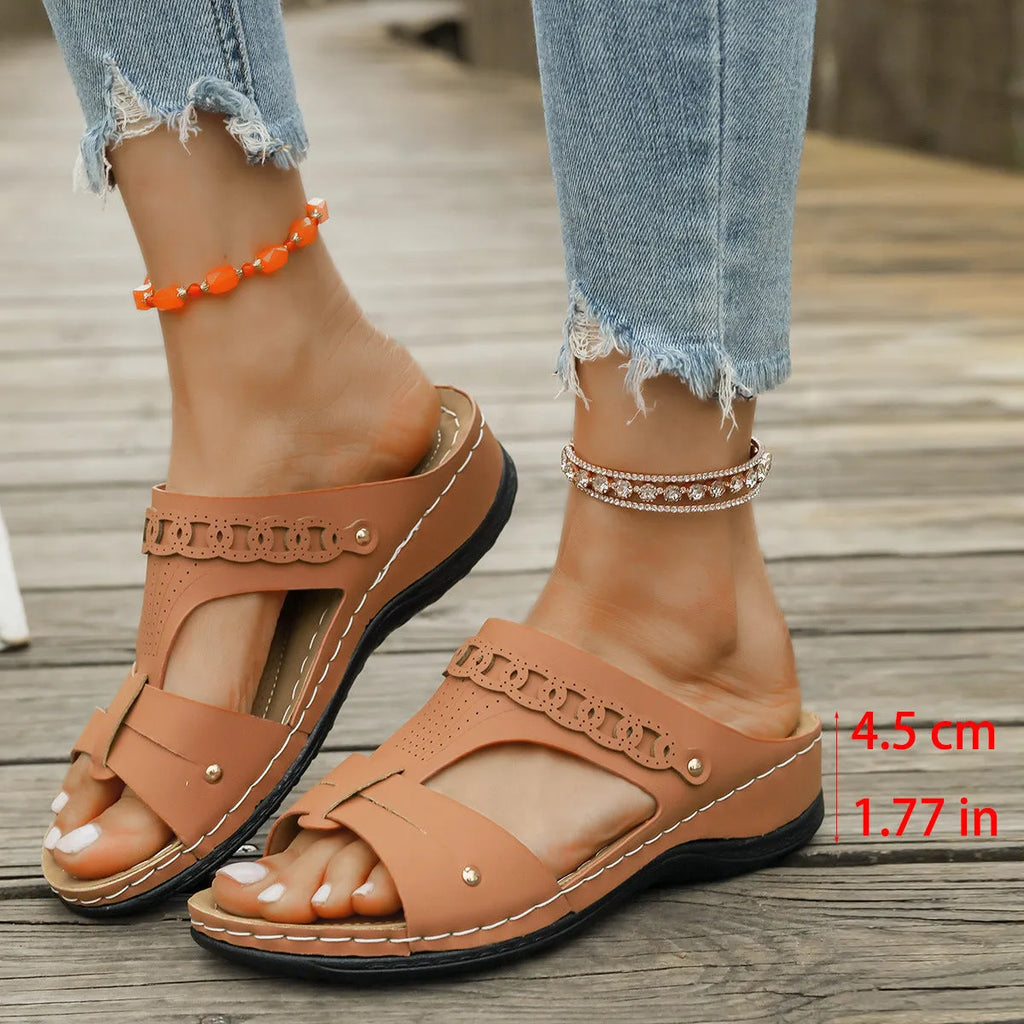 Blue roman style slippers with fish mouth toe and slope heel on a rubber sole.