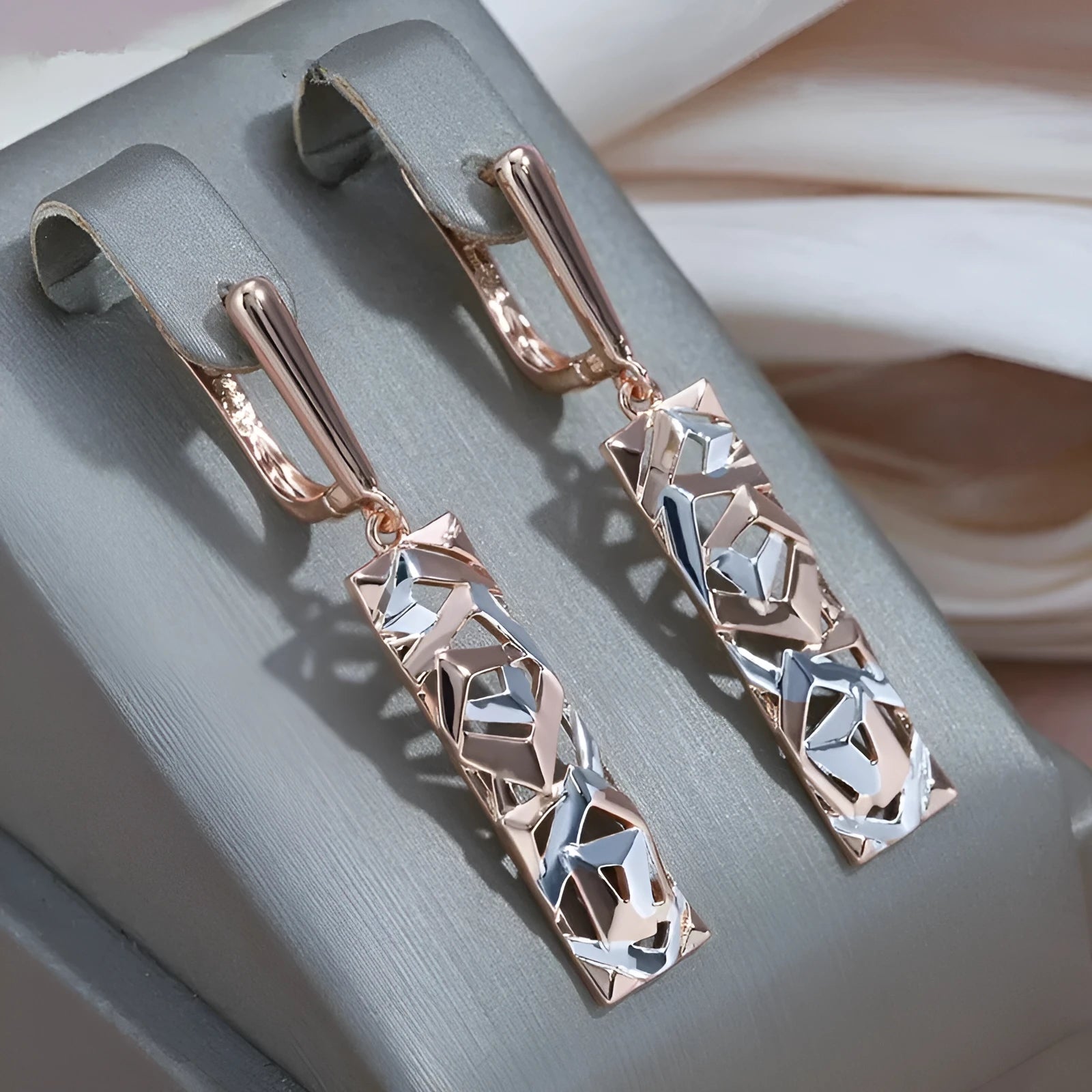 A pair of rectangular two-tone hollow stud earrings with a geometric design and electroplated alloy finish.