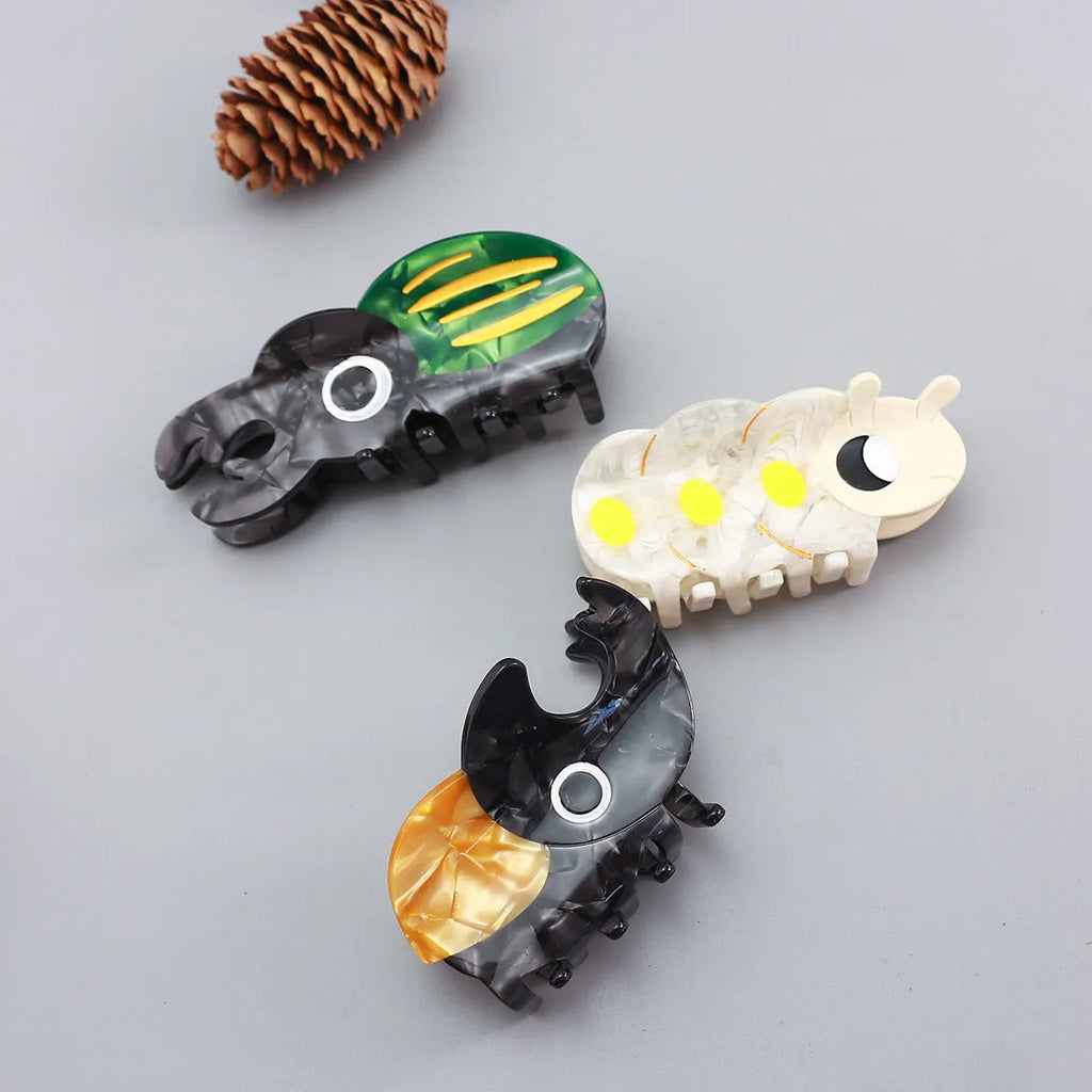 Handmade cellulose acetate beetle grip hair clip with cartoon caterpillar design in green, orange and white colours
