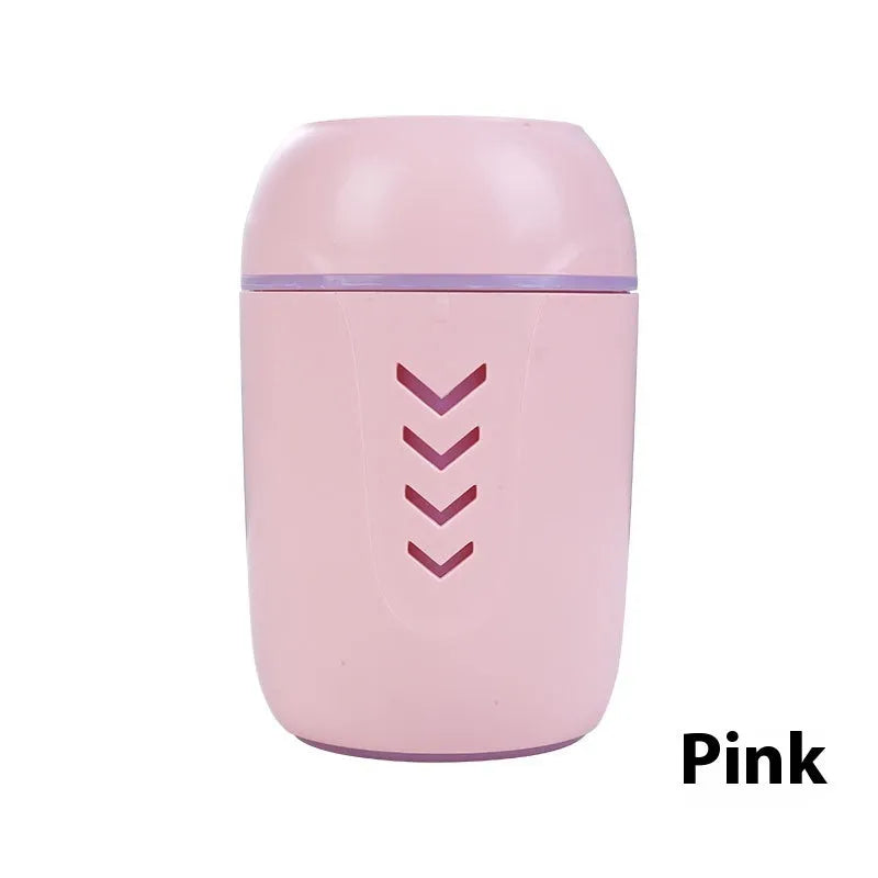 Round white portable air purifier with USB cable on a wooden desk.