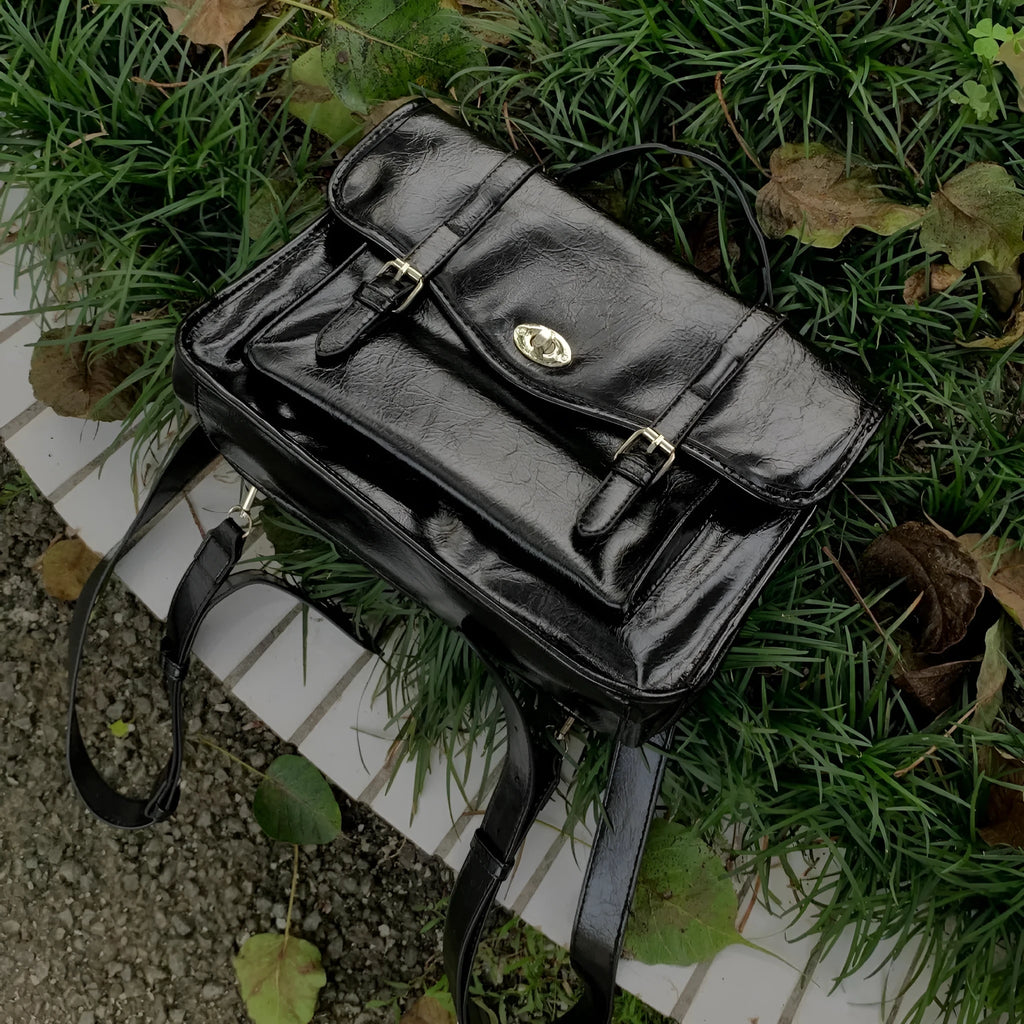 Black college style messenger bag with oil wax leather finish and compact 35cm design