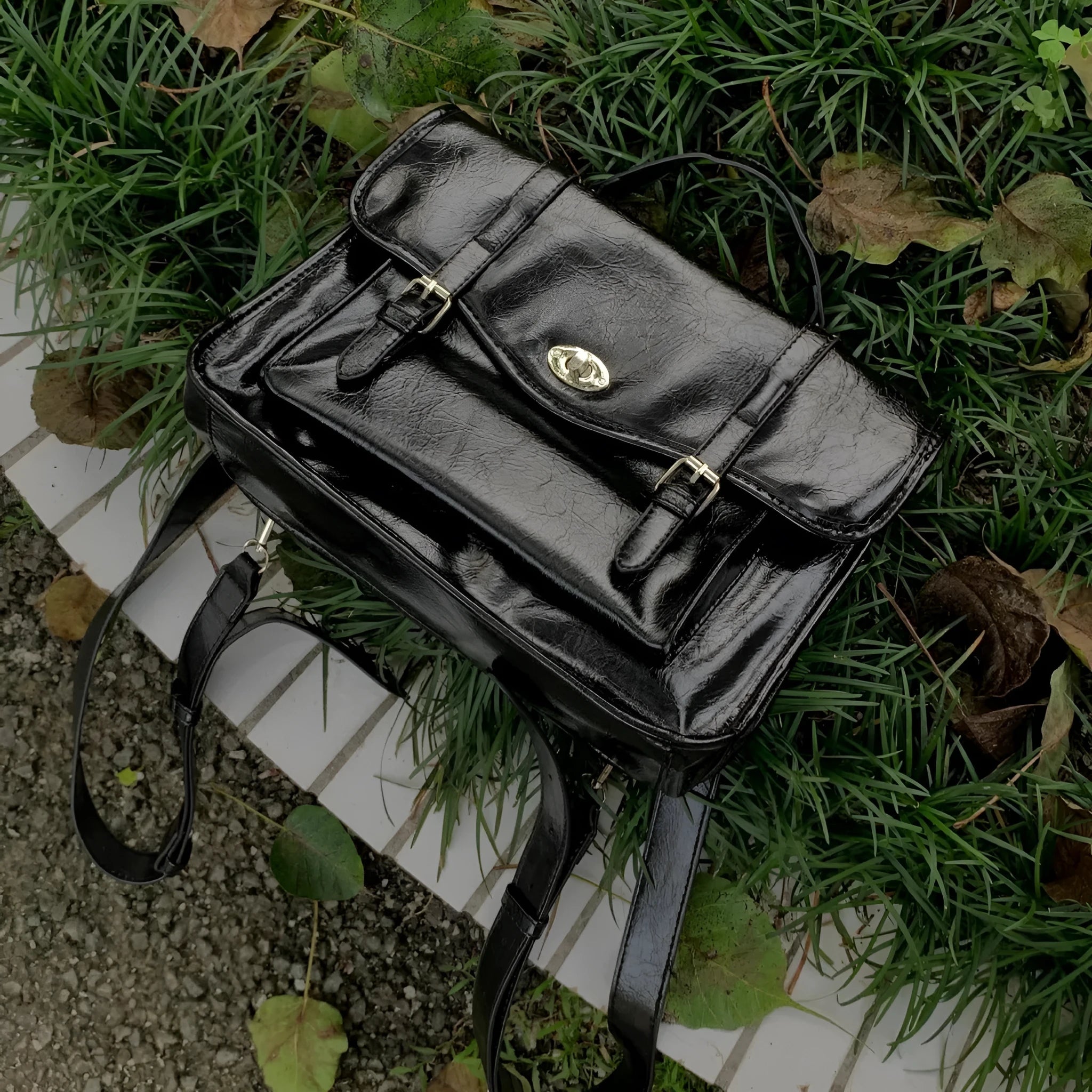 Black college style messenger bag with oil wax leather finish and compact 35cm design