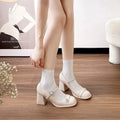 Women's black patent leather chunky heel shoes with round toe and buckle fastening.