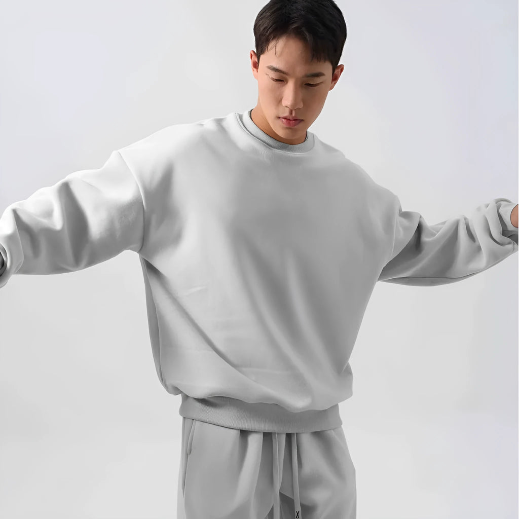 Men's black polar fleece sports suit with loose long sleeve coat and matching trousers on a hanger.