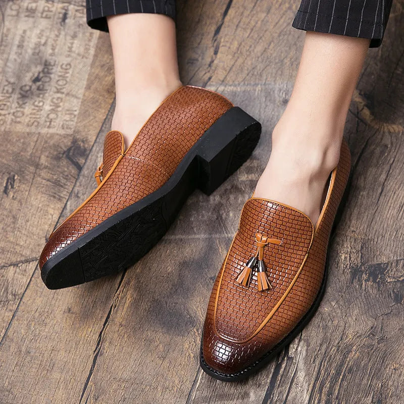 Men's black pointed slip-on leather shoes with a tassel detail on the low-top upper.
