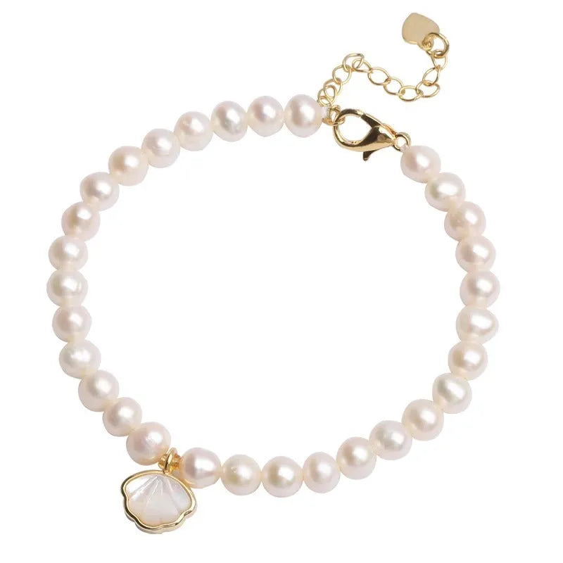 Close-up of a women's freshwater pearl fan bracelet on a wrist, showing elastic string and chain fastening options.