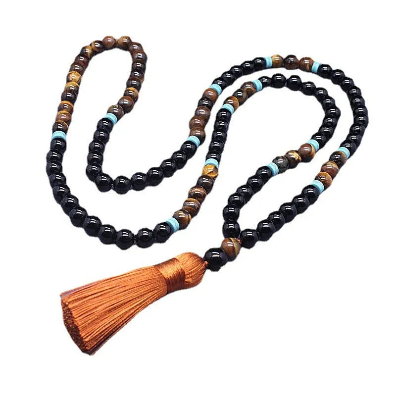 Black agate geometric bead bracelet and matching tiger-shaped tigereye stone necklace set on a grey background.