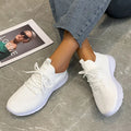 Women's low-top mesh running shoes in creamy white with Flyknit upper and rubber sole.