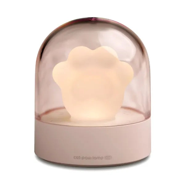 Grey and pink cat paw shaped USB night light with rotating lighting and music box features on desktop