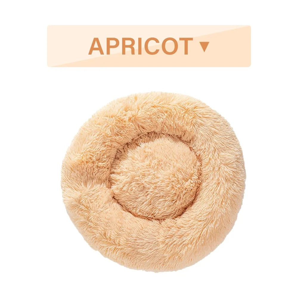 Fluffy donut-shaped pet bed in long plush material, showing raised edge and central well.