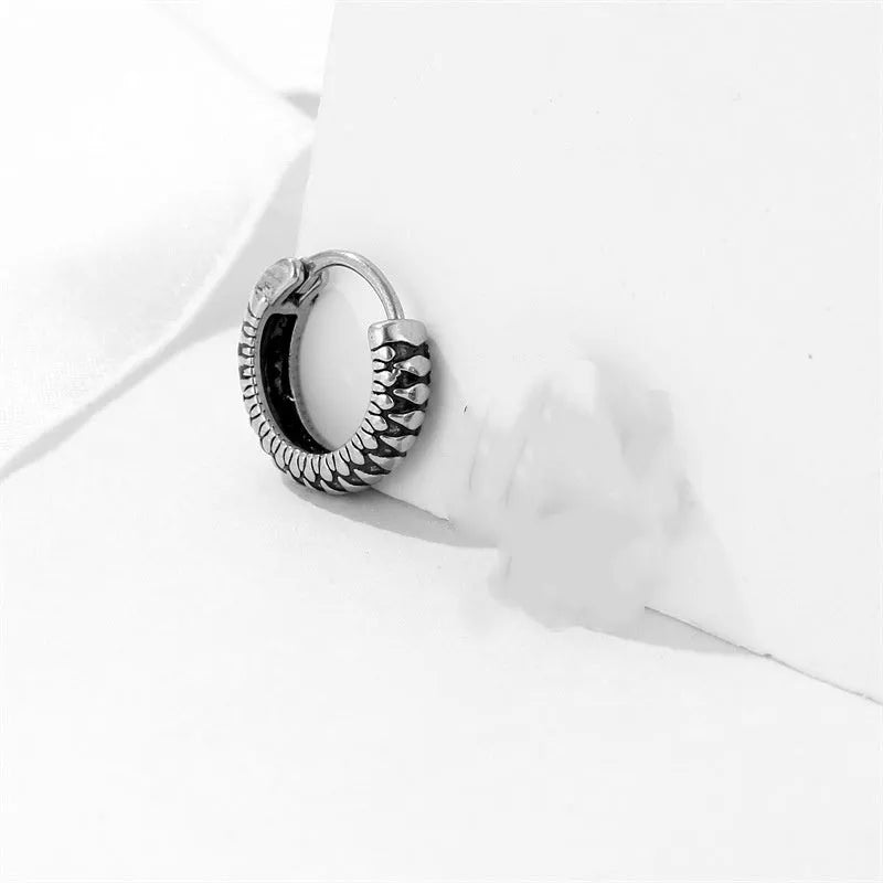 Silver geometric circular earrings made from twisted stainless steel stripes on a white background.